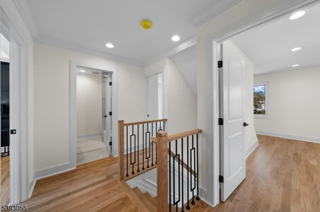 a view of a hallway with wooden floor and staircase