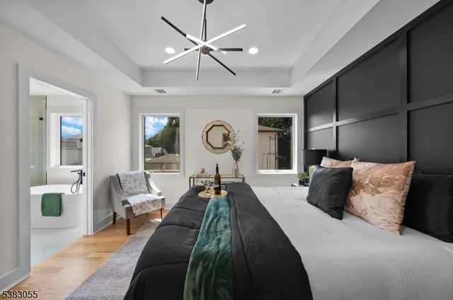 a bedroom with a large bed and a chandelier