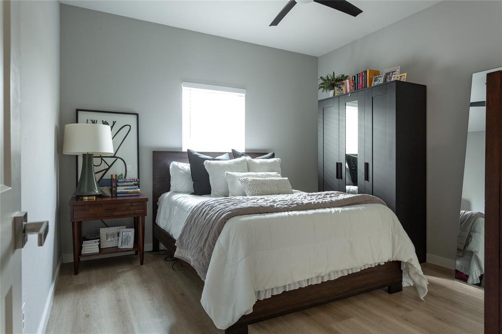 1108 Claude Street Dallas, TX 75203 - Photo 16 of 17 Room with light wood-finish flooring, a window with blinds, and a dark wood bed frame