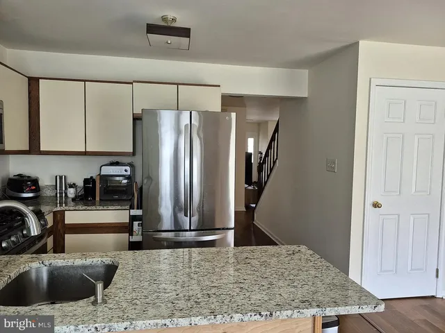 a kitchen with stainless steel appliances granite countertop a refrigerator and a sink