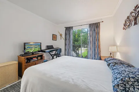 a bedroom with a bed and a flat tv screen on the dresser