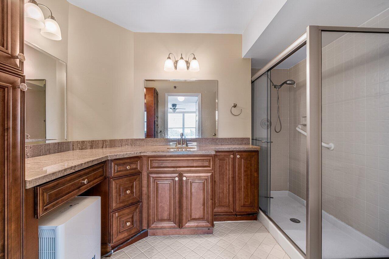 6530 Boca Del Mar Drive, Unit 336 Boca Raton, FL 33433 - Photo 14 of 22 a bathroom with a granite countertop sink a mirror and a shower