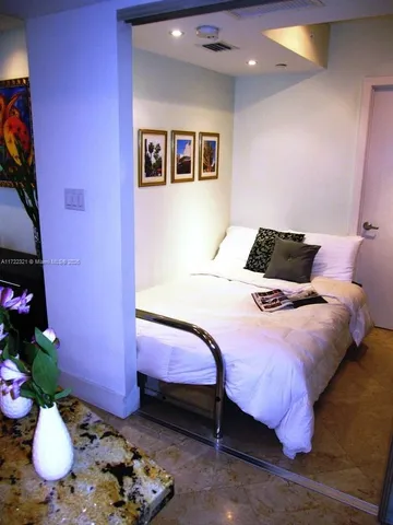 a bedroom with a bed and chandelier