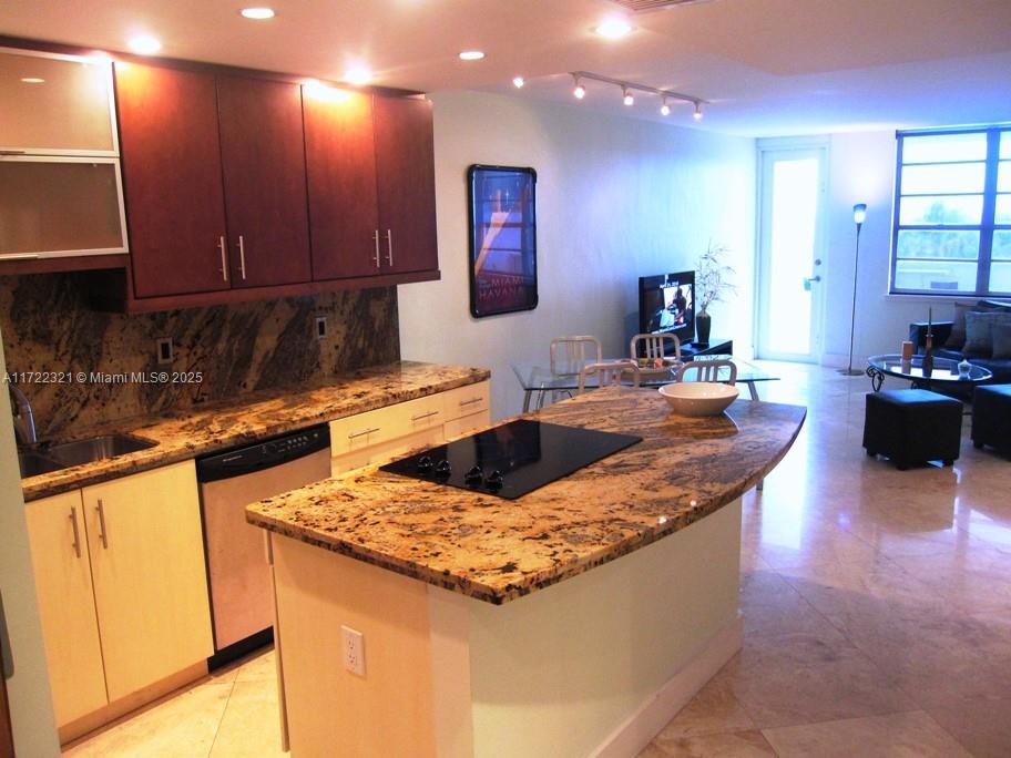 100 Lincoln Road, Unit 444 Miami Beach, FL 33139 - Photo 9 of 18 a kitchen with granite countertop a sink and a stove top oven with wooden floor