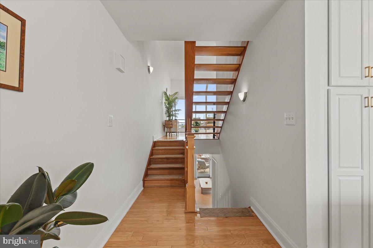 2409 Boston Street Baltimore, MD 21224 - Photo 14 of 46 a view of a hallway with wooden floor and stairs