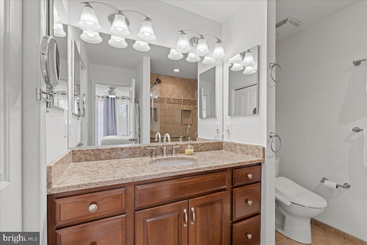 2409 Boston Street Baltimore, MD 21224 - Photo 35 of 46 a bathroom with a granite countertop sink a toilet and a mirror