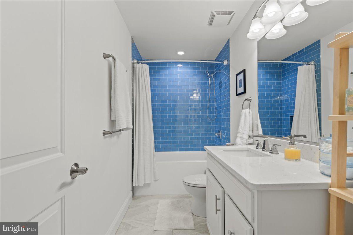 2409 Boston Street Baltimore, MD 21224 - Photo 41 of 46 a bathroom with a sink a toilet a mirror and shower