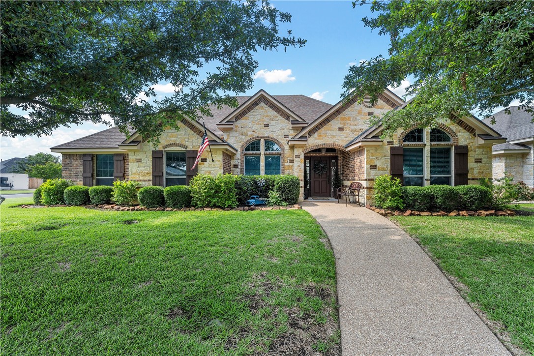 a front view of a house with a yard and potted plants