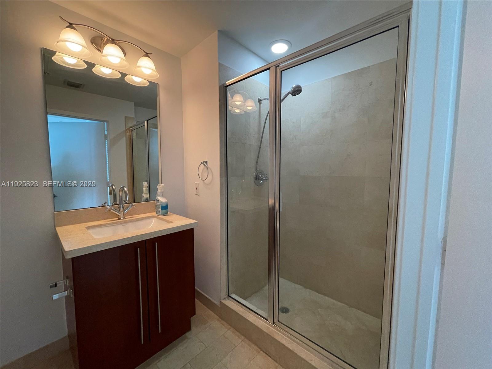 1111 Southwest 1st Avenue, Unit 2524N Miami, FL 33130 - Photo 10 of 11 a bathroom with a shower a mirror and a sink