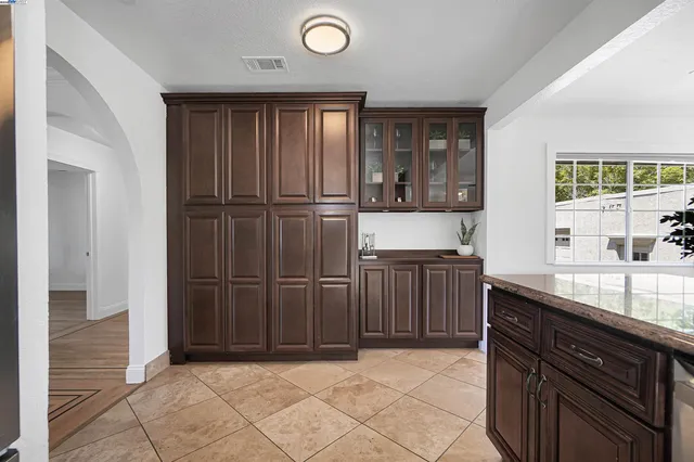 a kitchen with stainless steel appliances granite countertop a refrigerator a stove and a sink