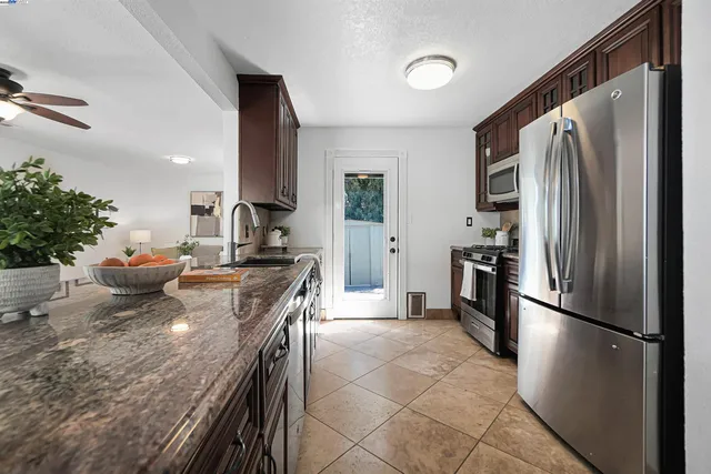 a kitchen with granite countertop stainless steel appliances and wooden cabinets