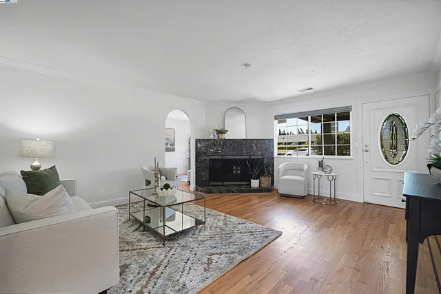 a living room with furniture a fireplace a rug and a window