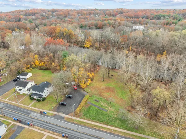 an aerial view of a house with a yard lake and mountain view in back