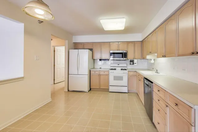 a kitchen with white cabinets and white appliances