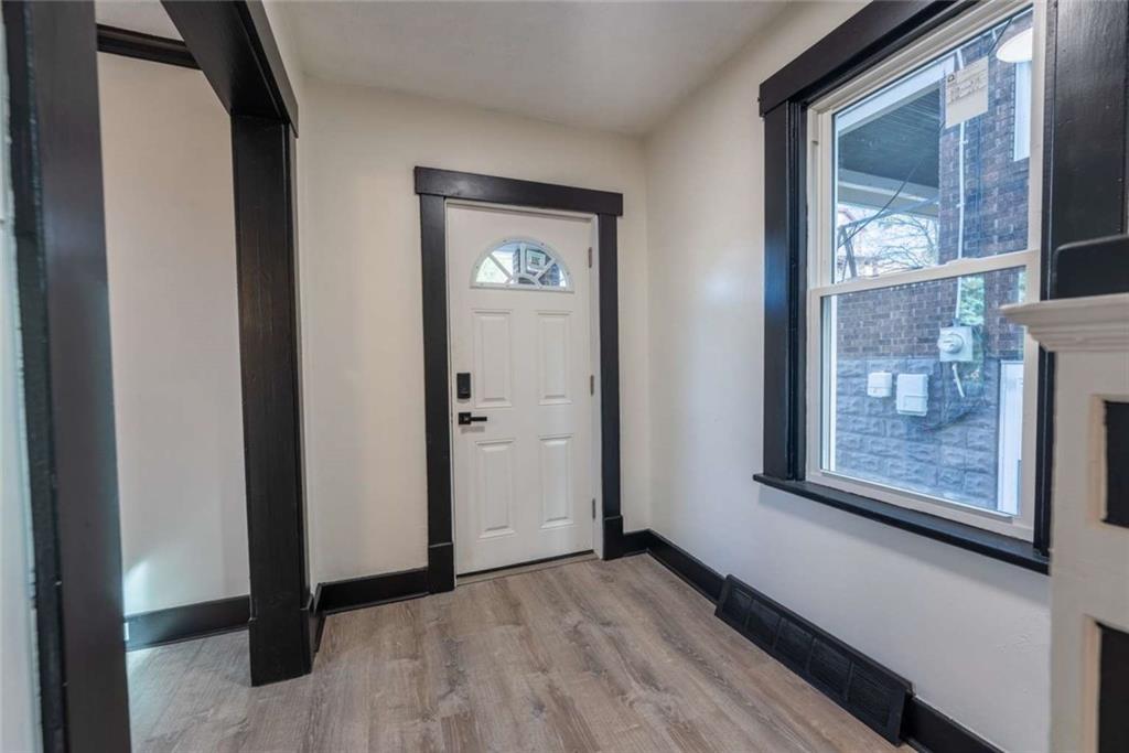 619 Barclay Avenue Pittsburgh, PA 15221 - Photo 14 of 23 a view of an empty room with wooden floor and a window