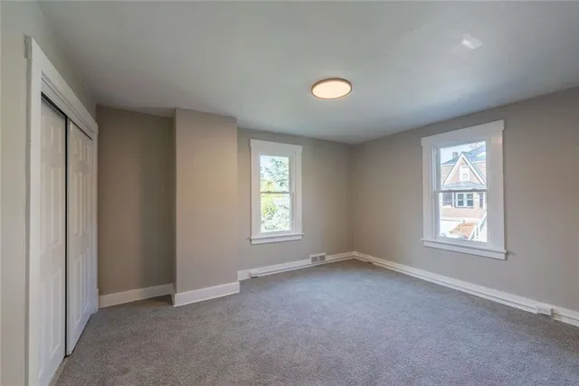 an empty room with windows and closet