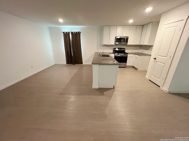 a kitchen with white cabinets and appliances