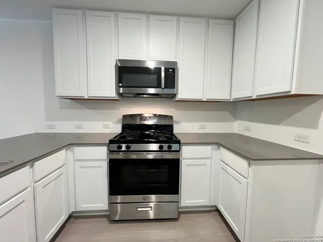 a view of a kitchen with white cabinets