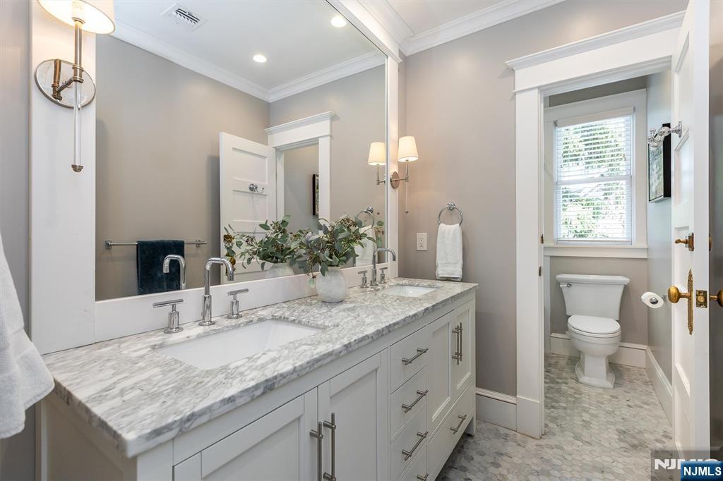 380 Ridgewood Avenue Glen Ridge, NJ 07028 - Photo 35 of 50 a bathroom with a granite countertop sink a toilet and a large mirror