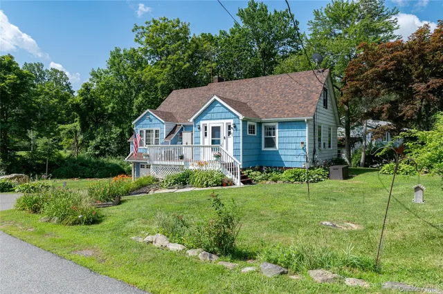 a view of a house with a big yard plants and large trees