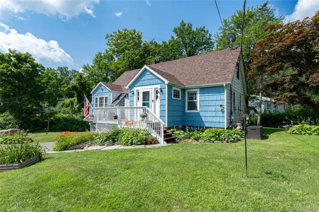 a view of a house with a yard and potted plants