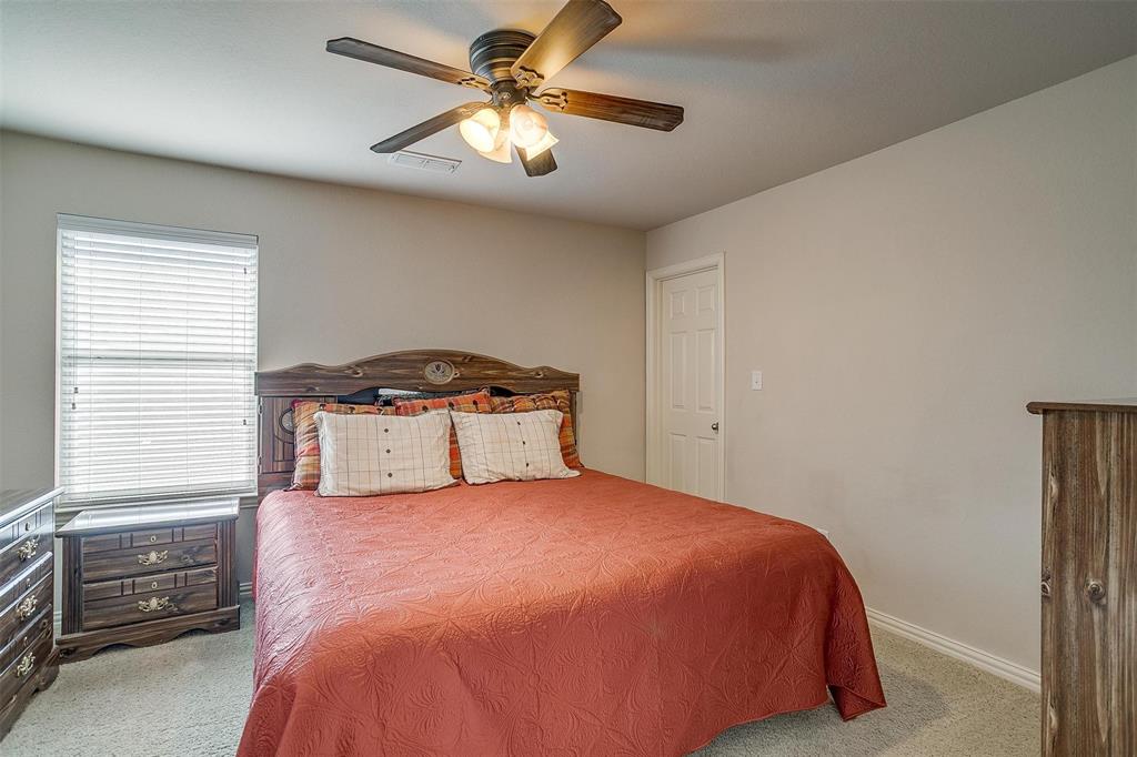 2536 Glenn Ranch Drive Burleson, TX 76028 - Photo 29 of 40 a bedroom with a bed and a chandelier