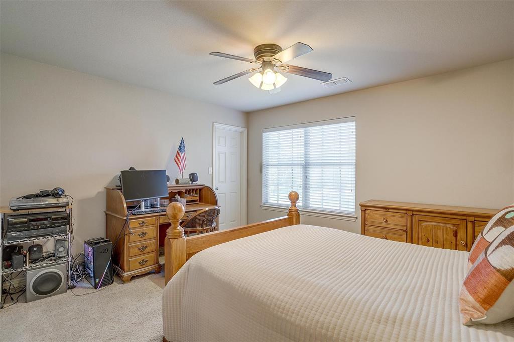 2536 Glenn Ranch Drive Burleson, TX 76028 - Photo 31 of 40 a bedroom with a bed and a chandelier