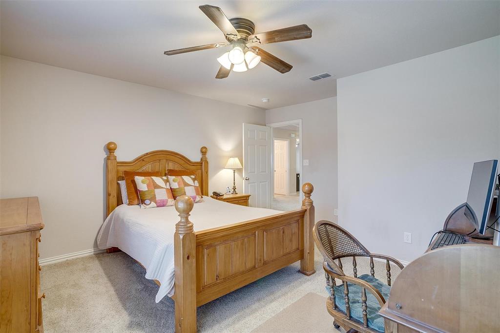 2536 Glenn Ranch Drive Burleson, TX 76028 - Photo 32 of 40 a bedroom with a bed and a chandelier