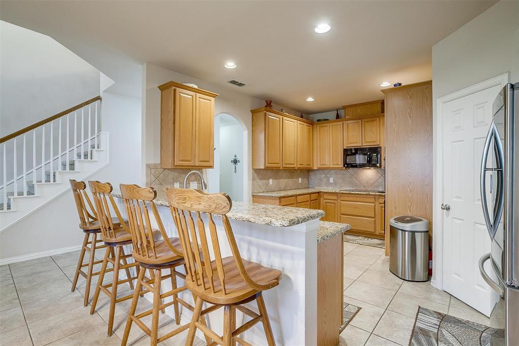 2536 Glenn Ranch Drive Burleson, TX 76028 - Photo 10 of 40 a kitchen with stainless steel appliances kitchen island granite countertop a refrigerator and a sink