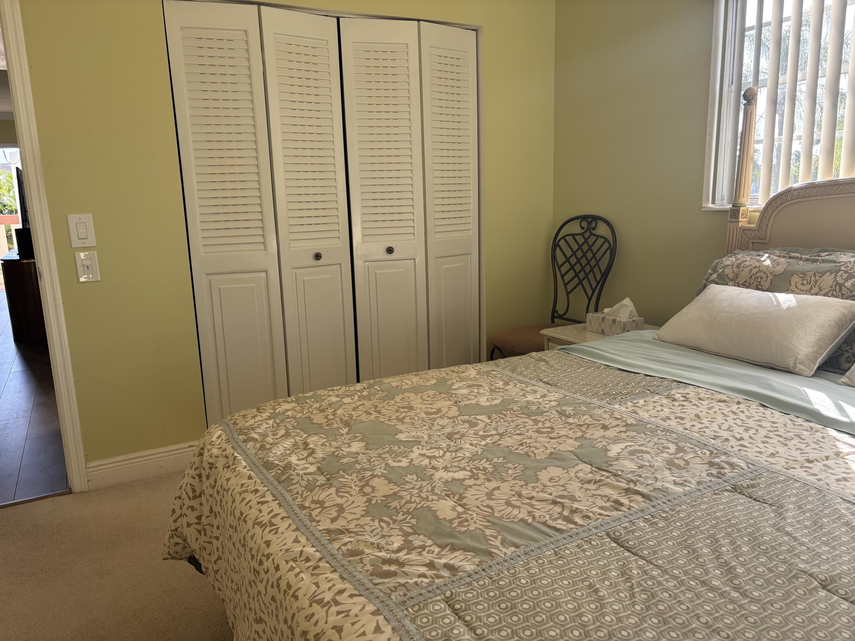 154 Preston F, Unit 154D Boca Raton, FL 33434 - Photo 11 of 17 a bedroom with a bed and wooden floor