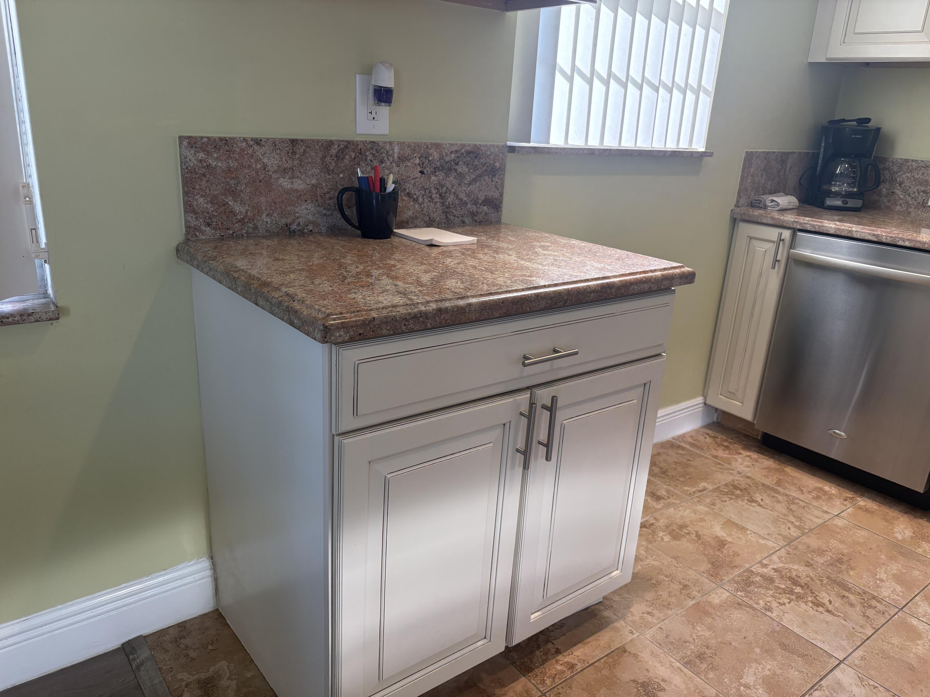 154 Preston F, Unit 154D Boca Raton, FL 33434 - Photo 3 of 17 a kitchen with stainless steel appliances granite countertop a sink stove and cabinets