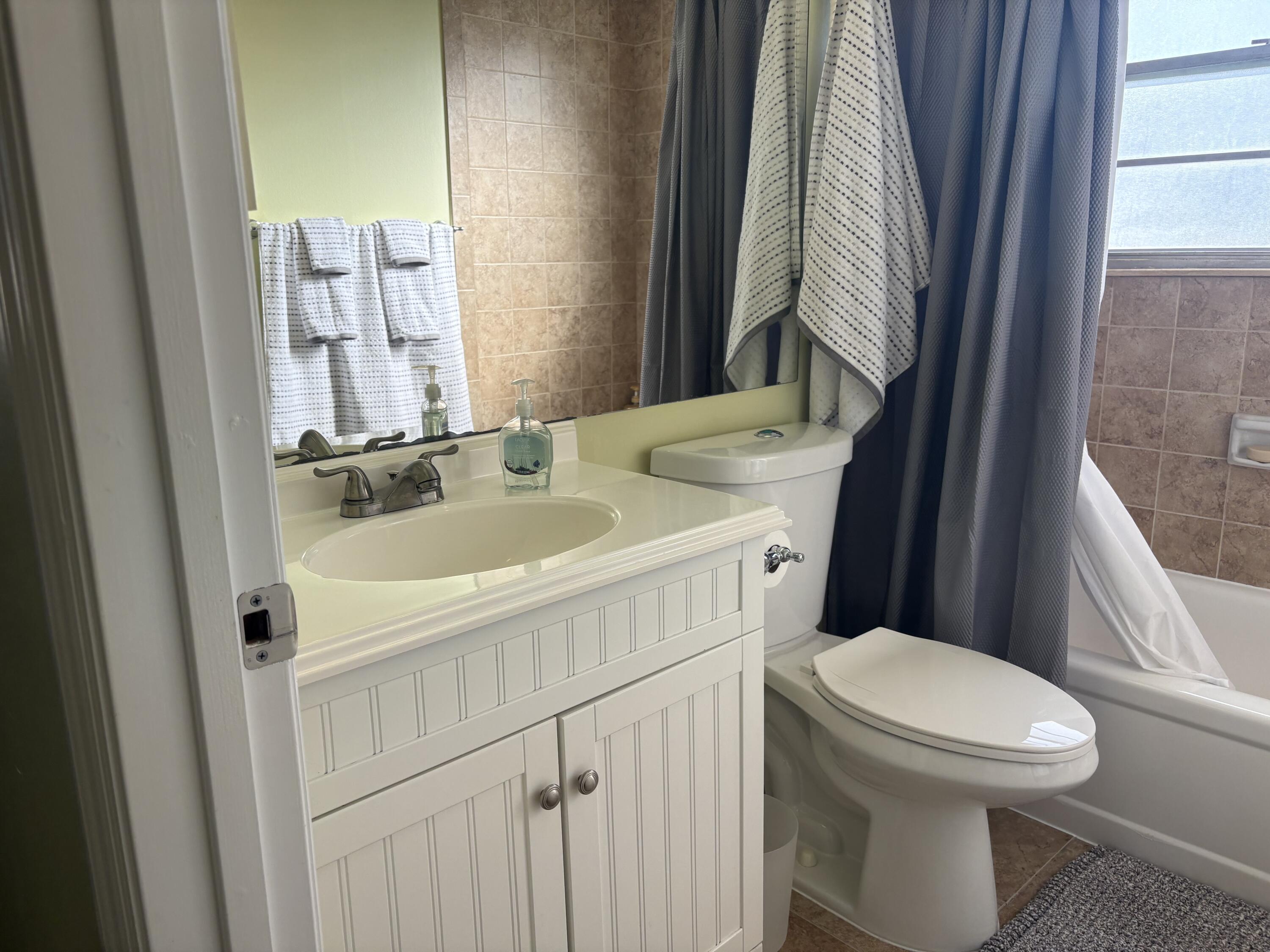 154 Preston F, Unit 154D Boca Raton, FL 33434 - Photo 9 of 17 a white toilet sitting next to a bathroom sink