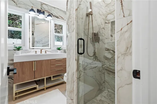 a bathroom with a double vanity sink a mirror a window and a shower