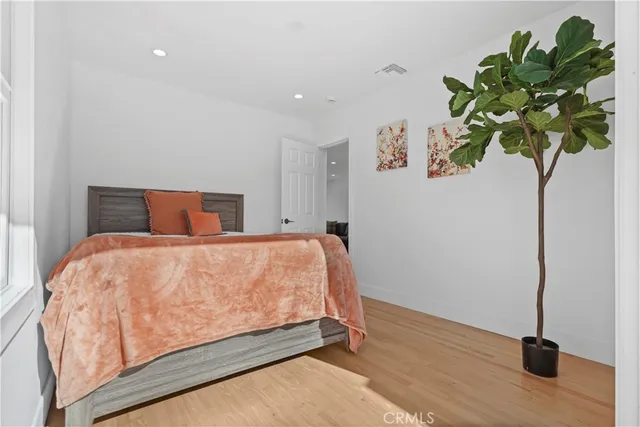 a bedroom with a bed and a potted plant
