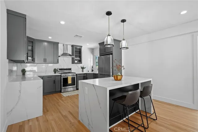 a kitchen with a table a sink cabinets and stainless steel appliances