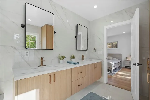 a en suite bathroom with a double vanity sink and a mirror