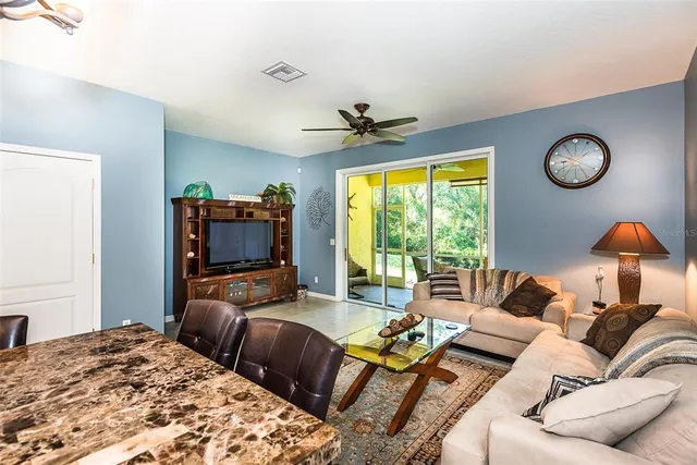 a living room with furniture a flat screen tv and a large window