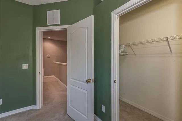 a view of a hallway with closet and wooden floor