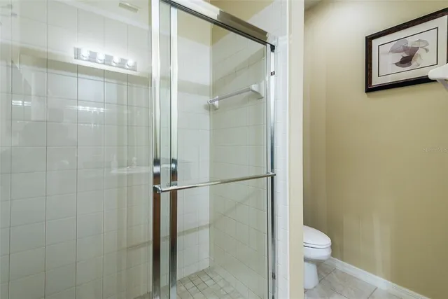 a bathroom with a granite countertop shower and a toilet
