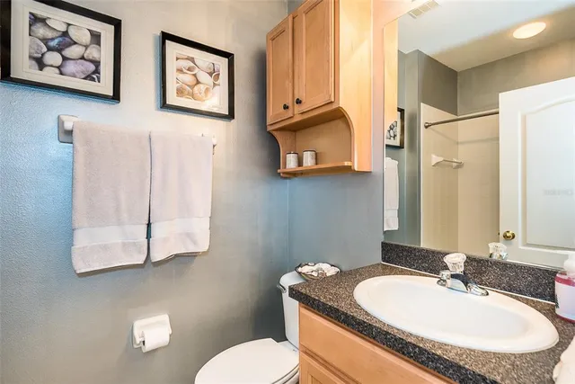 a bathroom with a granite countertop sink mirror vanity and toilet