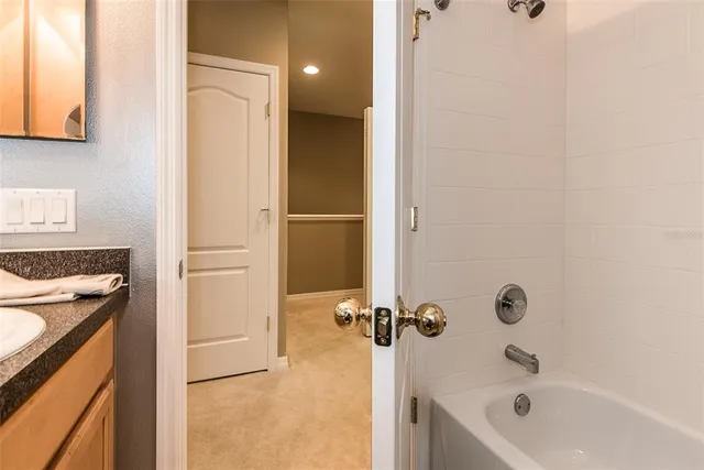 a bathroom with a tub sink vanity and toilet