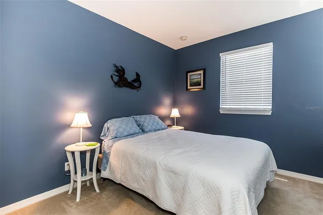 a bedroom with a bed and a table lamp