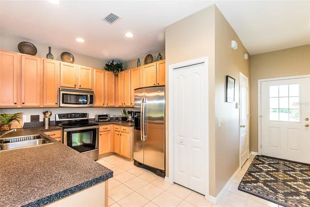 a kitchen with stainless steel appliances granite countertop a refrigerator a stove and a sink