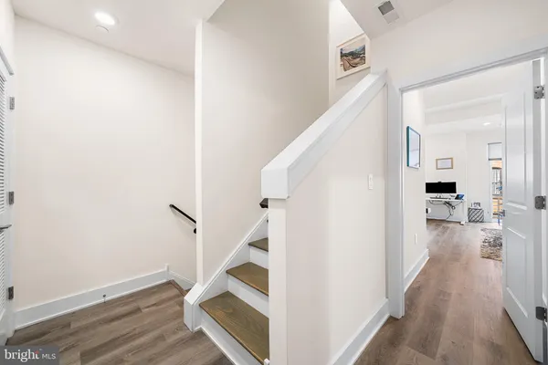 a view of a hallway with wooden floor and staircase