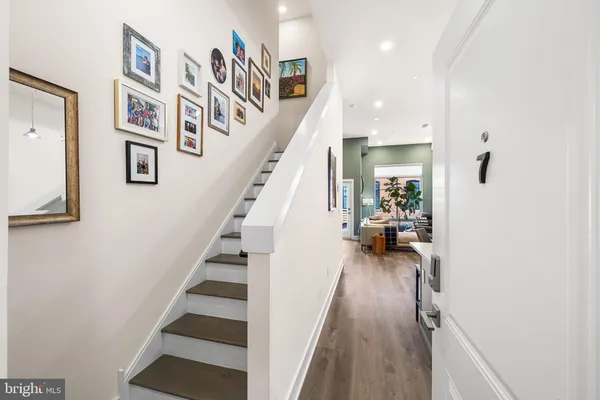 a view of entryway and hall with wooden floor