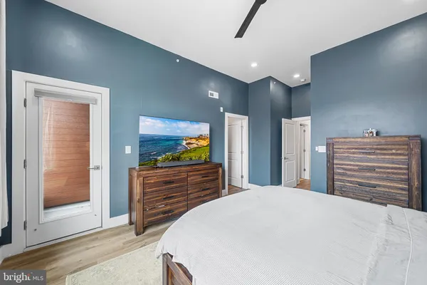 a bedroom with a bed and glass walk in closet