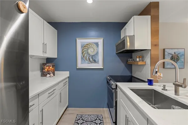a kitchen with stainless steel appliances granite countertop a sink stove and cabinets