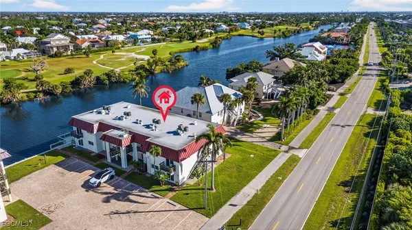 an aerial view of residential houses with outdoor space and ocean view