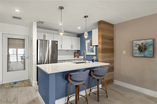 a kitchen with stainless steel appliances a table and chairs