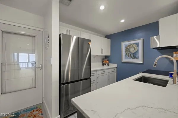 a kitchen with stainless steel appliances a refrigerator sink and microwave